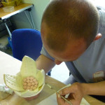 Man painting ceramic flower