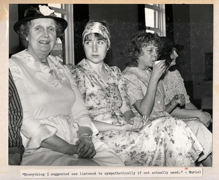 A black and white photo of 4 women sitting in a row.