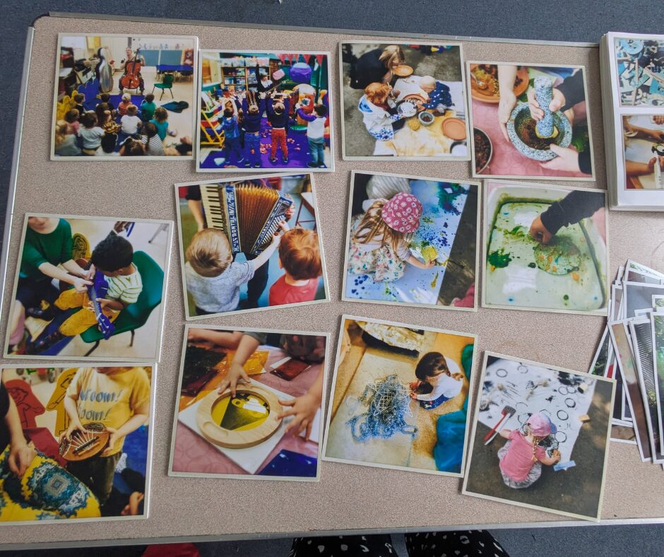 A table with various photos from the early years project's activities, including painting; various instruments, including an accordion; and other creative activities.