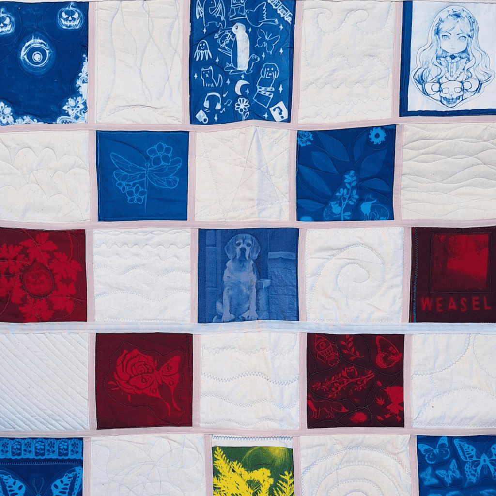A quilt made up of cyanotype squares each with different designs.