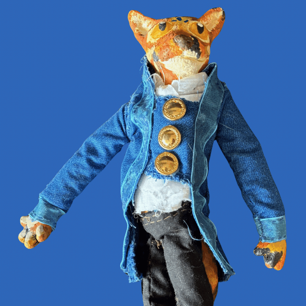 A fox puppet dressed in a blue trench coat.